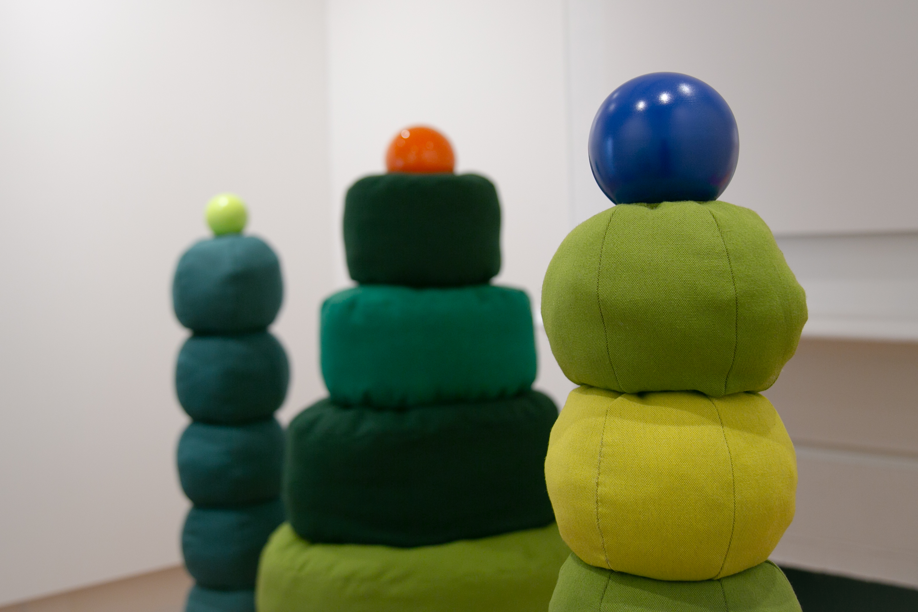 Green soft sculpture by Hanna Shim with green orange and blue baubles