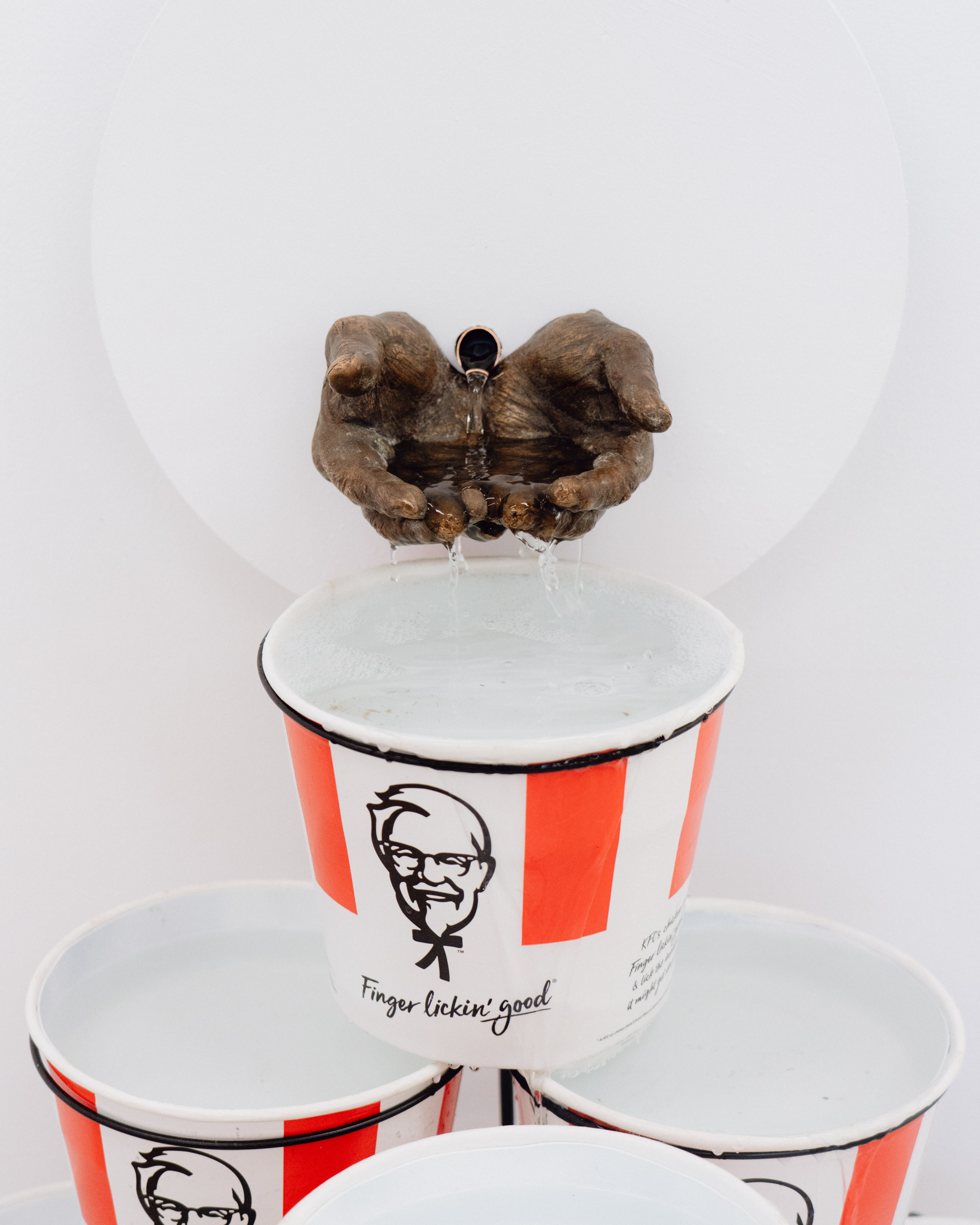 KFC buckets and bronze hands as fountain