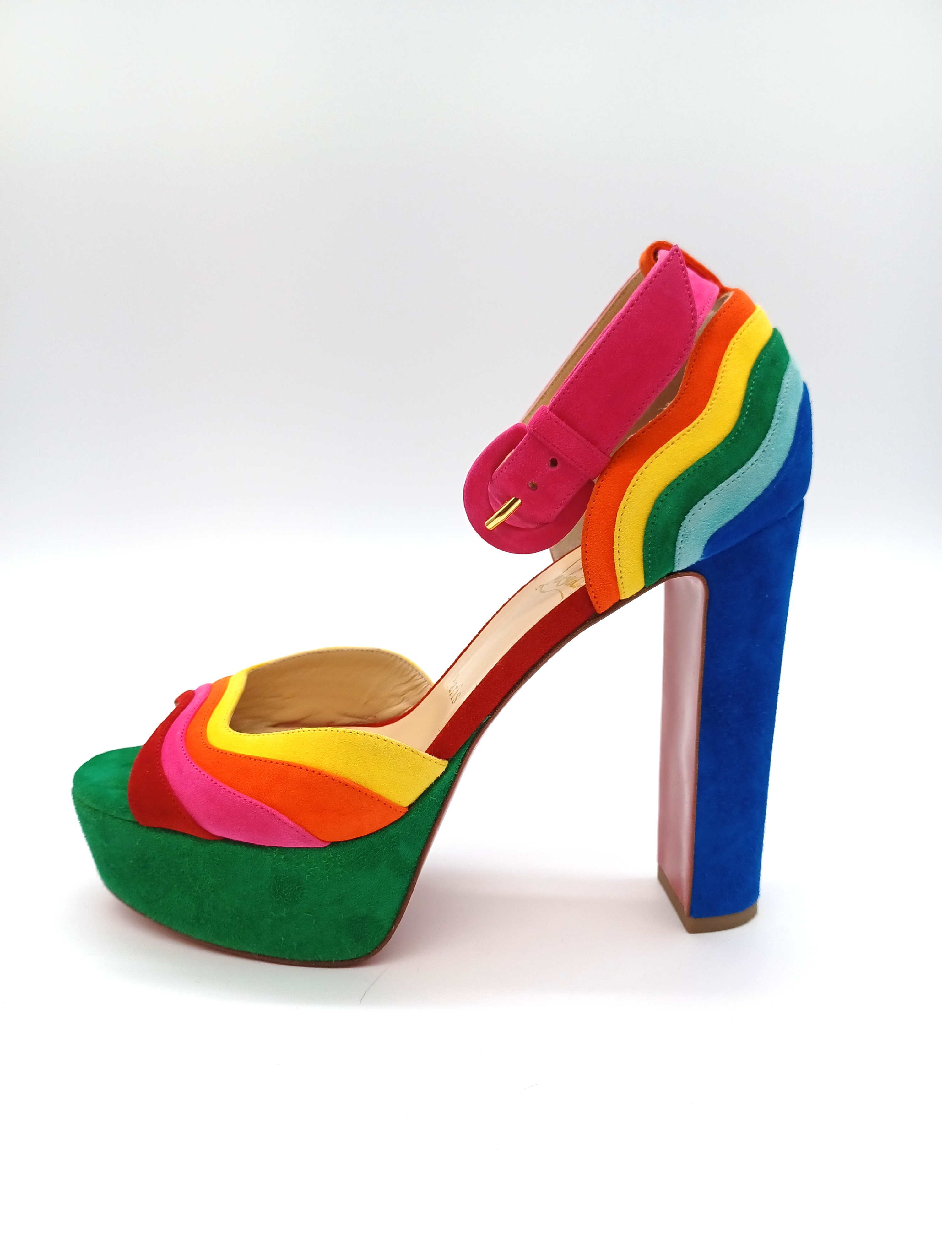 An image of a single high heeled shoe in vibrant rainbow colours by designer Christian Louboutin
