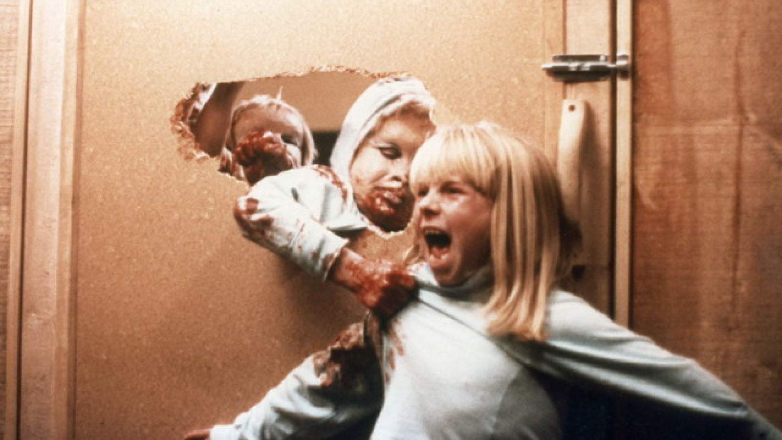 Film still of monstrous rage babies attacking a blond girl